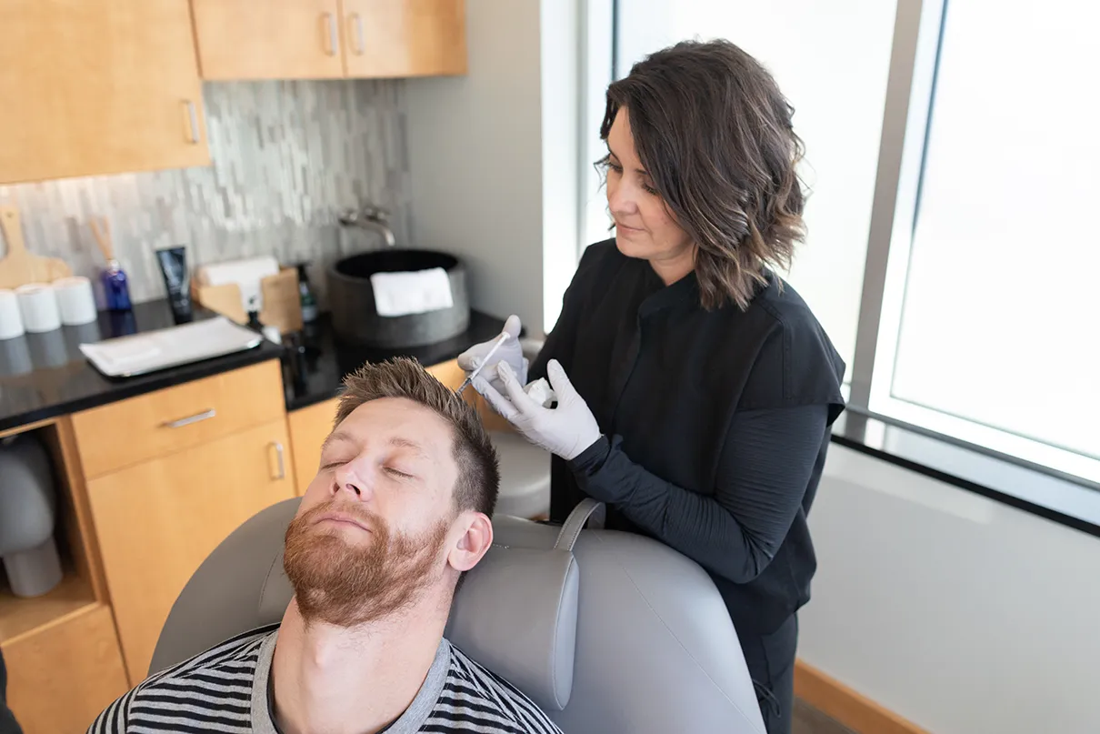 Kalon Provider performing hair restoration treatment to patient's scalp.